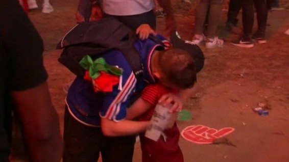 Португальский мальчик успокаивает плачущего французского болельщика